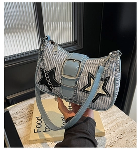 Détails du sac à main tissé bleu et blanc avec écussons étoiles noires et chaîne argentée