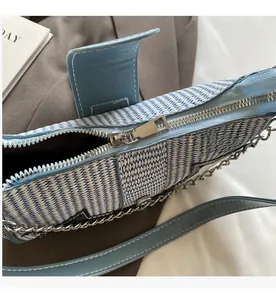 Détail de la fermeture éclair argentée et texture tissée du sac bleu clair