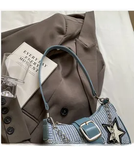 Détail d'un sac à bandoulière tissé bleu et blanc avec motif étoile et chaîne métallique