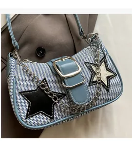 Détail du sac à bandoulière tissé bleu et blanc avec écusson étoile et chaîne en métal