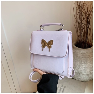 Détail d'un mini sac à dos lavande avec fermoir papillon doré et poignée supérieure