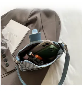 Détail montrant l'intérieur spacieux d'un sac sous le bras en pied-de-poule bleu et blanc