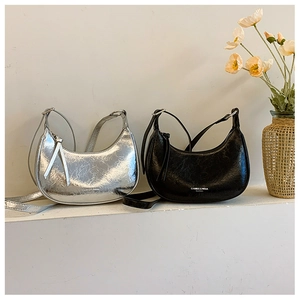 Détail des sacs demi-lune argent et noir en cuir froissé de qualité avec texture brillante