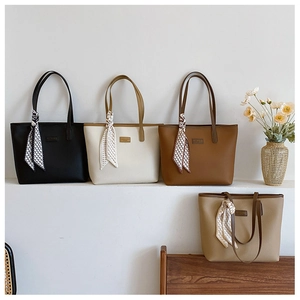 Detail of multi-color tote bags with lychee leather texture and silk scarf decoration