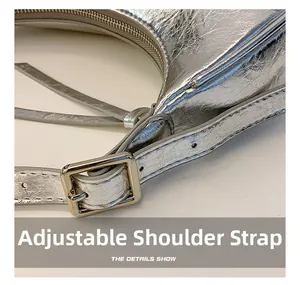 Détail de la boucle réglable et de la texture cuir argenté sur le sac baguette chic