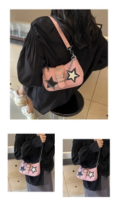 Détail du sac sous le bras tissé rose avec étoiles noires et blanches et chaîne argentée