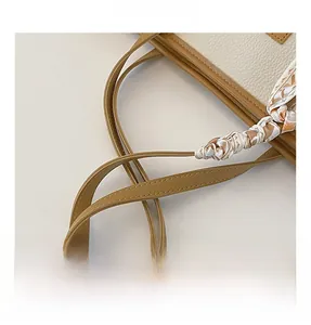 Detail of caramel lychee grain tote bag with silk scarf wrapped handle and contrast stitching