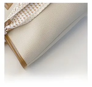 Detail of cream lychee leather texture and silk scarf accent on a stylish tote bag