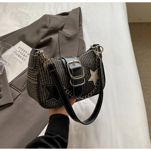 Détail d'un sac bandoulière tissé avec patch étoile et bandoulière en chaîne
