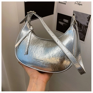 Détail d'un sac argenté métallisé avec logo gaufré et texture plissée élégante
