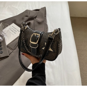 Détail d'un sac sous l'aisselle tissé avec boucle en métal, chaîne et patch en étoile