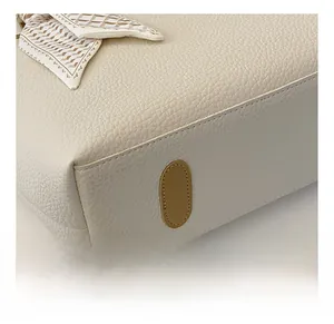 Detail showing the pebble grain leather texture, reinforced bag bottom, and scarf detail