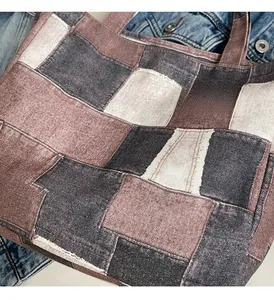 Detail shot of a patchwork denim tote bag with purple and grey canvas fabric panels