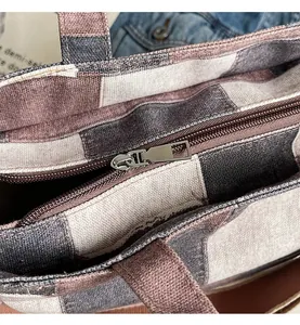 Close-up of smooth metal zipper detail on durable plaid canvas tote bag for women