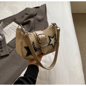 Détail d'un sac bandoulière en paille tressée avec patchwork d'étoile et chaîne argent