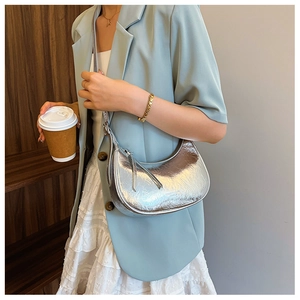 Détail du sac à main argenté métallisé avec finition brillante et fermeture éclair chic