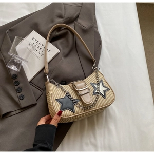 Détail du sac à bandoulière en paille avec texture tissée et patchs d'étoiles