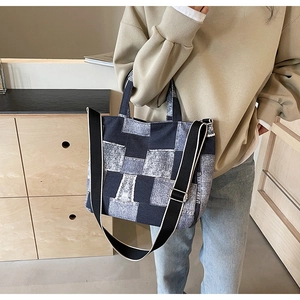 Detail of patchwork denim tote bag showing wide adjustable strap and large capacity