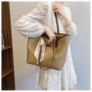 Detail of a large brown pebbled tote bag with geometric silk scarf and spacious interior