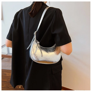 Détail du sac croissant argenté métallisé avec texture plissée sur blazer