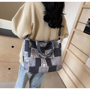 Detail of patchwork denim tote bag with gray washed squares and adjustable strap