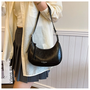 Détail du sac demi-lune en cuir noir avec logo blanc et boucle en métal argenté