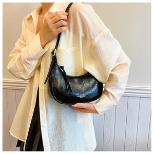 Détail du sac hobo noir brillant avec texture plissée et bandoulière réglable