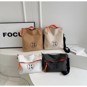 Detail view of stylish canvas tote bags in four colors with orange contrast handles
