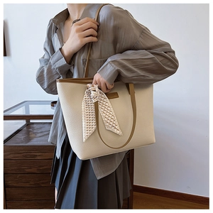 Close-up of lychee grain tote bag with brown straps and elegant checkered silk scarf