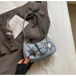 Détail du sac tissé à carreaux bleu et blanc avec écusson étoile et chaîne en métal
