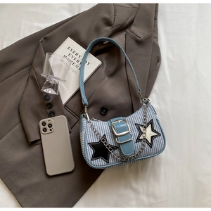 Détail du sac à main tissé bleu et blanc avec écusson étoile et chaîne métallique argentée