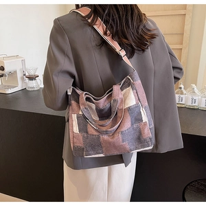 Model wearing a color-block patchwork denim tote bag with adjustable shoulder strap