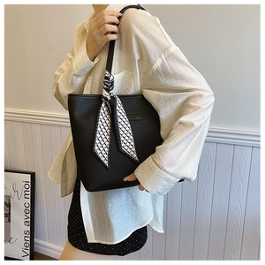 Chic black lychee leather tote bag with elegant black and white checkered silk scarf detail