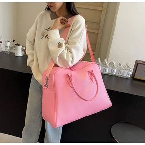 Close-up of pink large capacity travel tote bag with pebble leather texture and strap