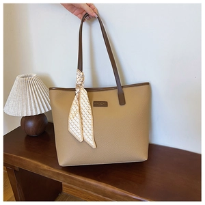 Detail of khaki tote bag featuring lychee texture leather and a checkered silk scarf