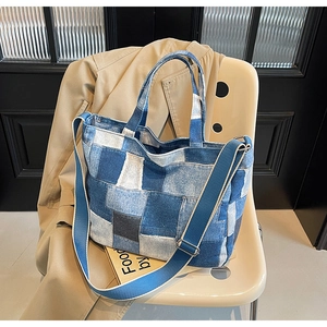 Close-up of patchwork denim tote bag with adjustable wide fabric shoulder strap