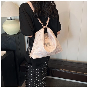 Detail of pink butterfly pattern leather backpack with silver metallic bow clasp