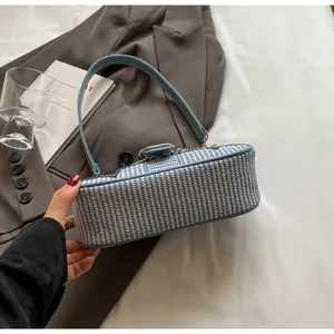 Détail de la texture tissée bleu clair d'un sac sous l'aisselle sur un blazer gris