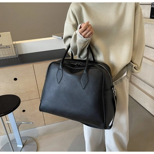 Detail of black lychee grain leather tote bag with silver hardware and adjustable strap