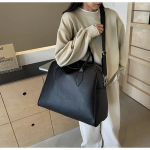 Detailed side view of black lychee grain tote with silver hardware and shoulder strap