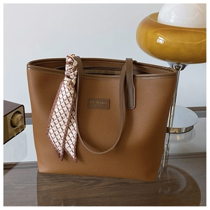 Close-up of brown lychee texture tote bag with elegant silk scarf and metal zipper detail