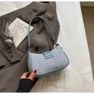 Gros plan sur la texture tissée bleue et blanche avec finitions vernies sur le sac