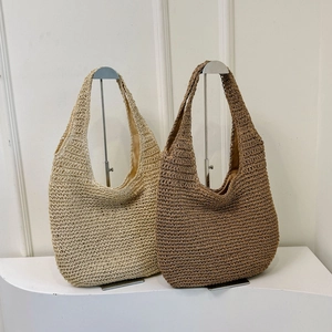 Detail of straw tote bags in beige and brown with woven texture and fabric lining