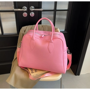 Close-up of pink large capacity travel tote bag with pebble leather texture on a white chair