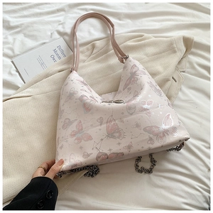 Detail of light pink tote bag with butterfly print and silver metal chain decoration