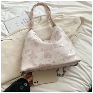 Detail of pink butterfly tote bag showing medium capacity next to a smartphone