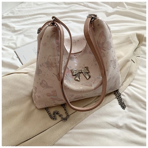 Close-up of light pink tote bag featuring butterfly print and silver metal bow buckle