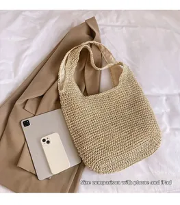 Handwoven straw tote bag shown next to a smartphone and tablet for size comparison