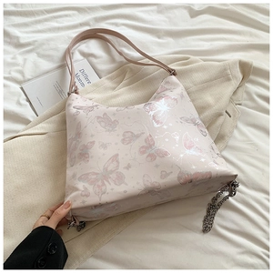 Macro detail of pink leather butterfly tote bag with silver chain and starry pattern