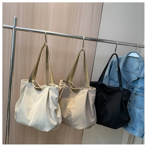 Detailed display of large capacity pleated tote bags in off-white, khaki, and black colors